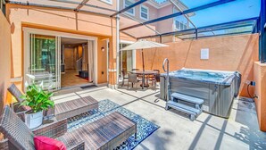 An outdoor patio with a hot tub, seating area, and a covered walkway. - The Mouse’s House/Private Retreat/Close to Disney (Kissimmee)