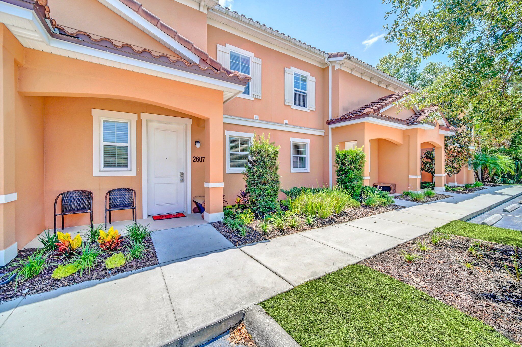 A row of townhouses with a front porch, a mailbox, and a number 2607 on the door.