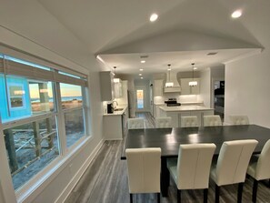 A modern kitchen with white cabinets, a central island, and pendant lighting.