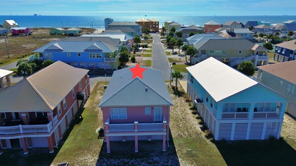 A coastal residential area with houses featuring gabled roofs and a prominent red star on one building.