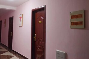 A hallway with a wooden door marked '367', a checkered floor, and a framed sign on the wall. - Lijiang Hotel (Xinyi Railway Station) (Xinyi)