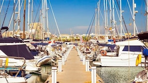 Un port de plaisance où de nombreux bateaux sont amarrés le long d’une jetée en bois.