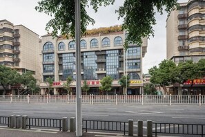 A multi-story building with large windows, a flat facade, and a fence in the foreground. - Beiduola Boutique Hotel (Xiamen Airport SM City Plaza) (Xiamen)
