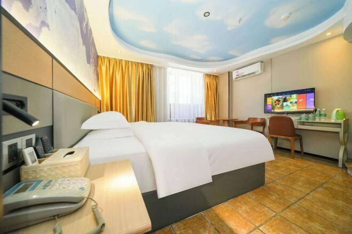 Een hotelkamer met een bed, bureau, stoel en een televisie.