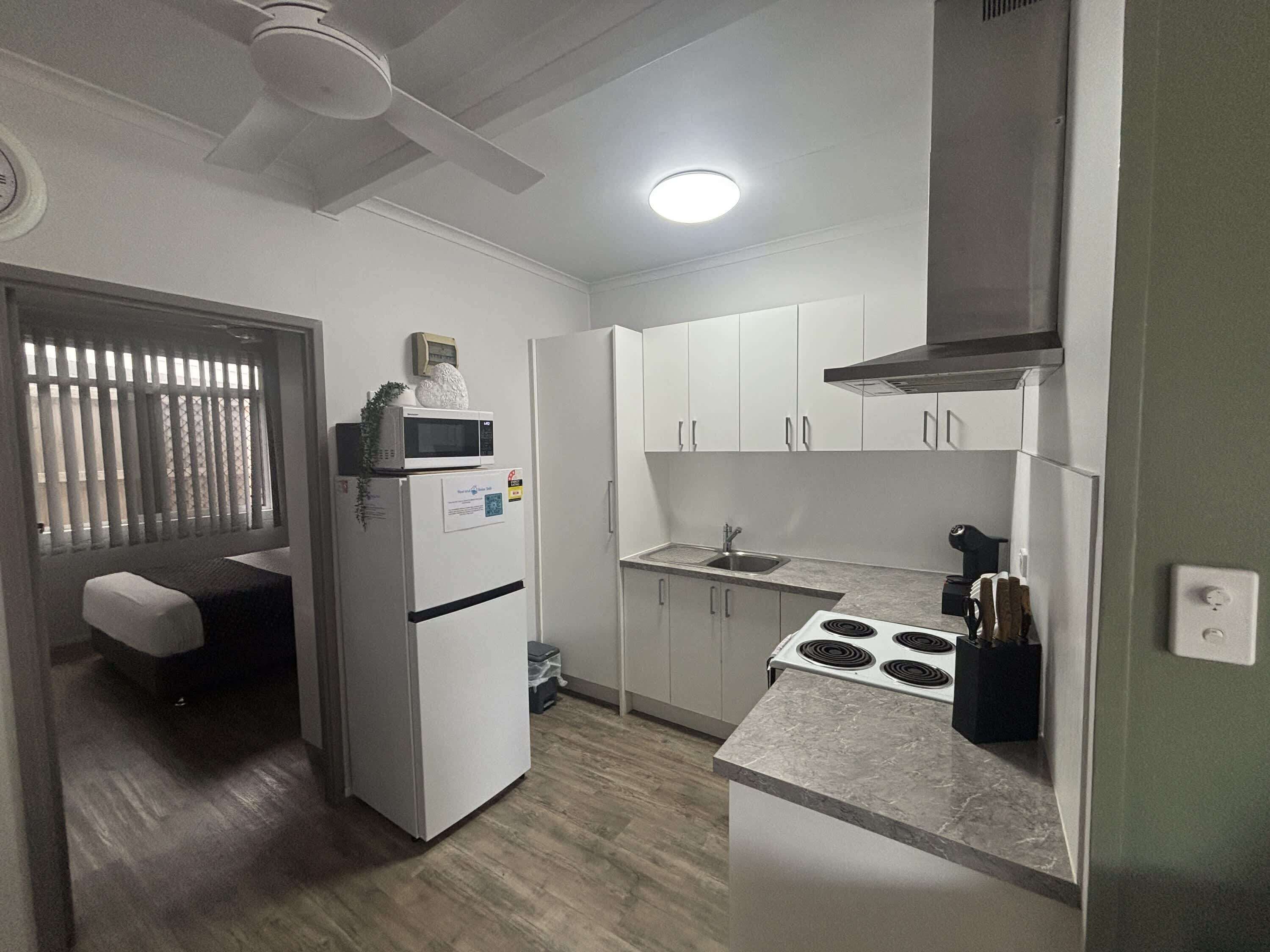 The kitchen opens onto the living area, with the second bedroom just through the doorway.