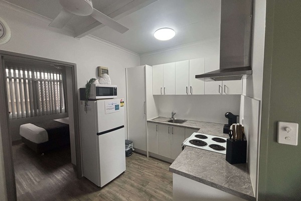 The kitchen opens onto the living area, with the second bedroom just through the doorway.