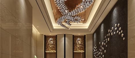 A modern interior with a unique ceiling design, vertical light fixtures, and patterned wall panels.