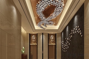 Un intérieur moderne avec un design de plafond original, des luminaires verticaux et des panneaux muraux à motifs.