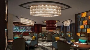 A modern interior with a bar area, seating with cushions, and a patterned carpet. - Zhengda International Hotel (Jiangling)
