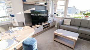 A modern living room with a flat-screen TV, sofa, and coffee table.