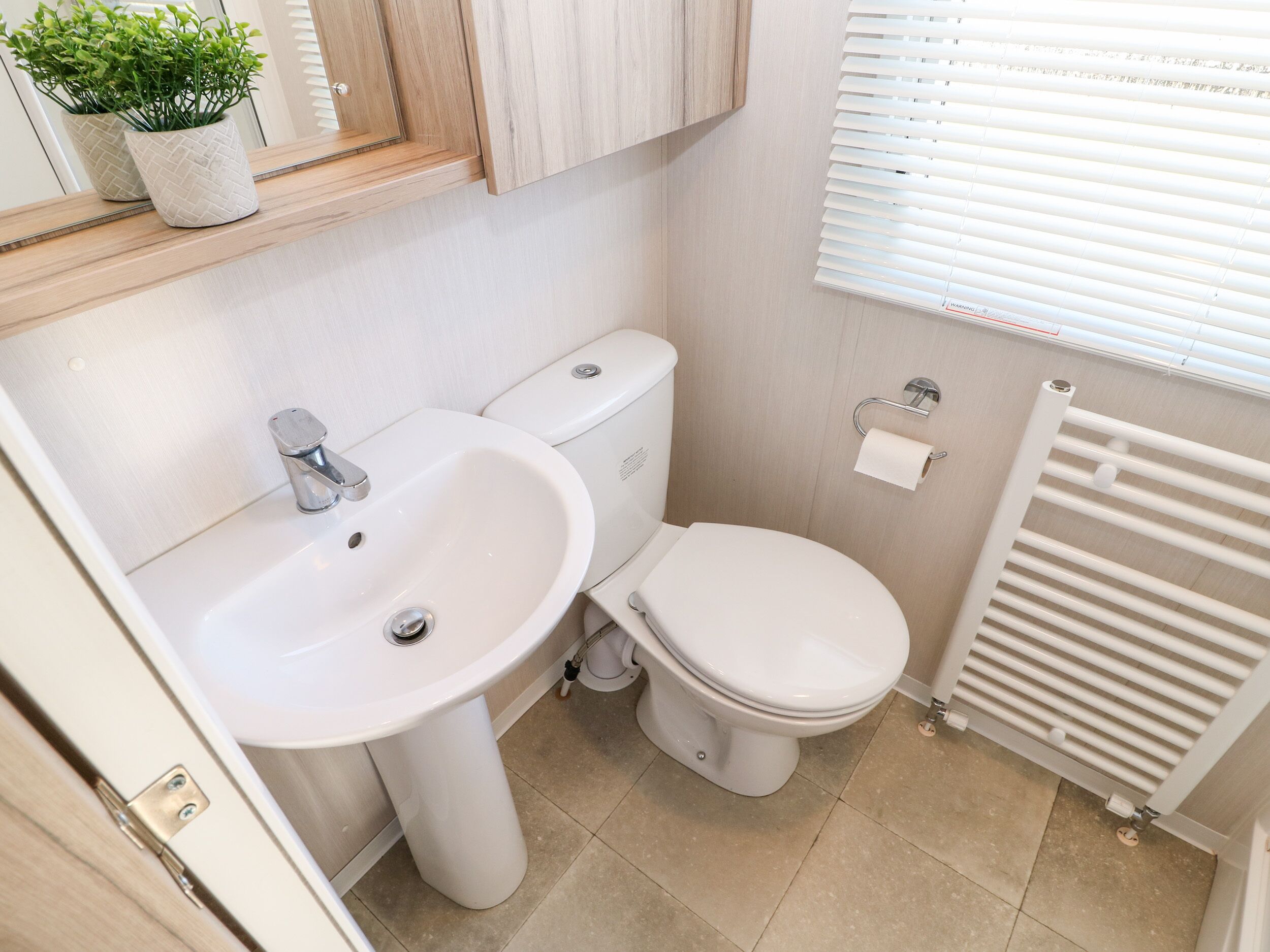 Un baño pequeño con lavabo, inodoro y radiador.