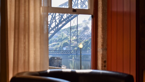 A room with a view of a bridge and hills. - Apartamento com 2 Quartos Varanda e Vista rio 3º Andar (Porto)