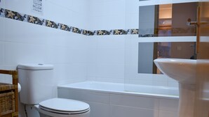 A bathroom with a toilet, bathtub, and sink. - Apartamento com 2 Quartos Varanda e Vista rio 3º Andar (Porto)