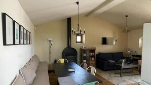 A compact living space with a dining table, sofa, and kitchenette. - Rural house among olive trees (Biar)