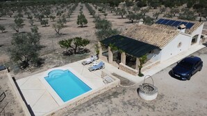 A villa with a swimming pool, outdoor seating, and a car parked nearby. - Rural house among olive trees (Biar)