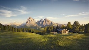A mountain landscape with a small house in the foreground. - 5 minutes from the Alpe di Siusi cable car, family apartment and terrace. (Seis am Schlern)
