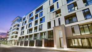 A multi-story hotel with a modern architectural design, featuring balconies and large windows. - Studio Win Herastrau (Bucharest)