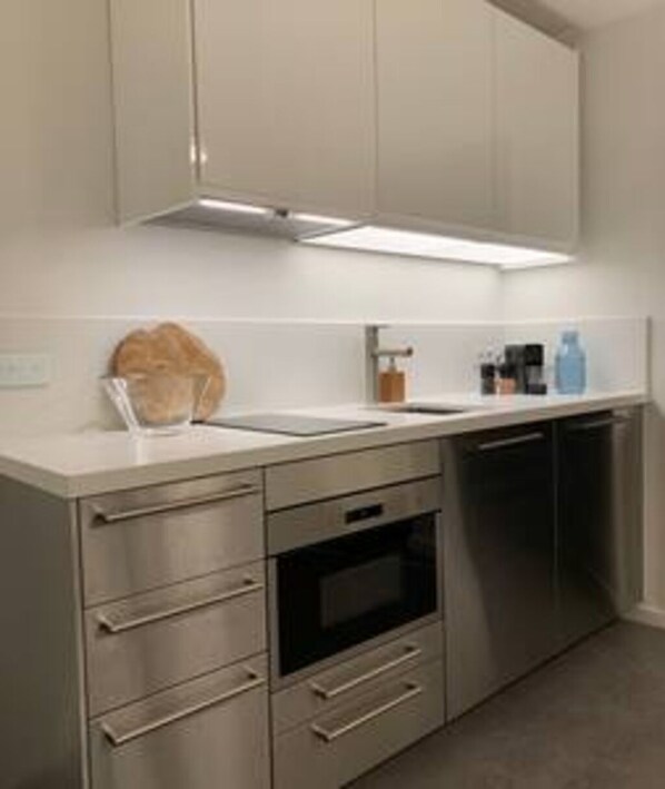 Eine moderne Küche mit Edelstahlgeräten, einem Backofen und einem Geschirrspüler.