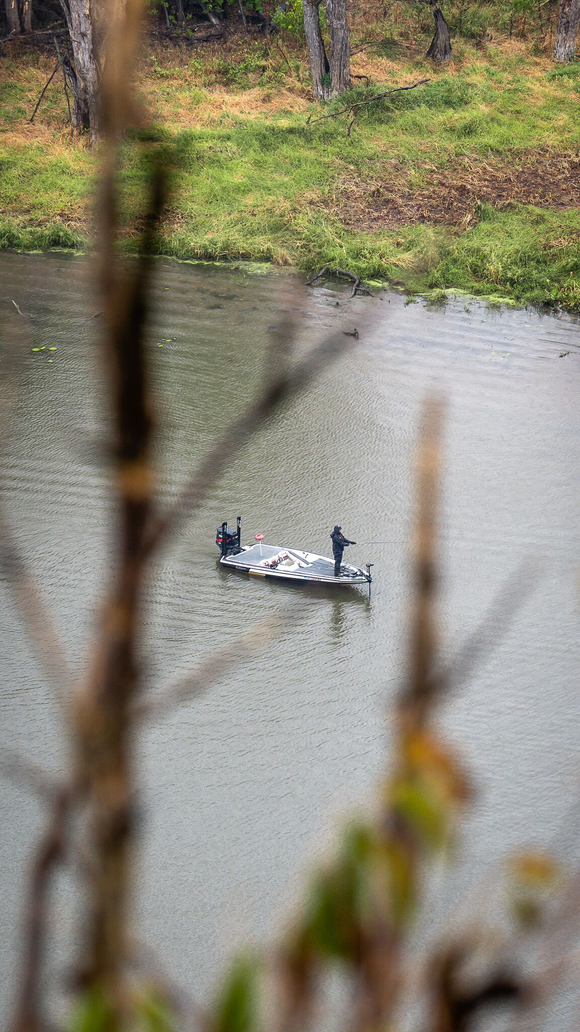 A boat on a calm lake with a person standing on the bow.