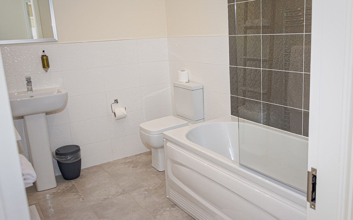 A bathroom with a white sink, toilet, and bathtub.