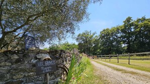 A stone wall with a sign indicating 'Les Gravets' parking and 'Maison d'Rotes'. - Fleur des Champs" caravan, Nordic bath and shared pool (Sigalens)