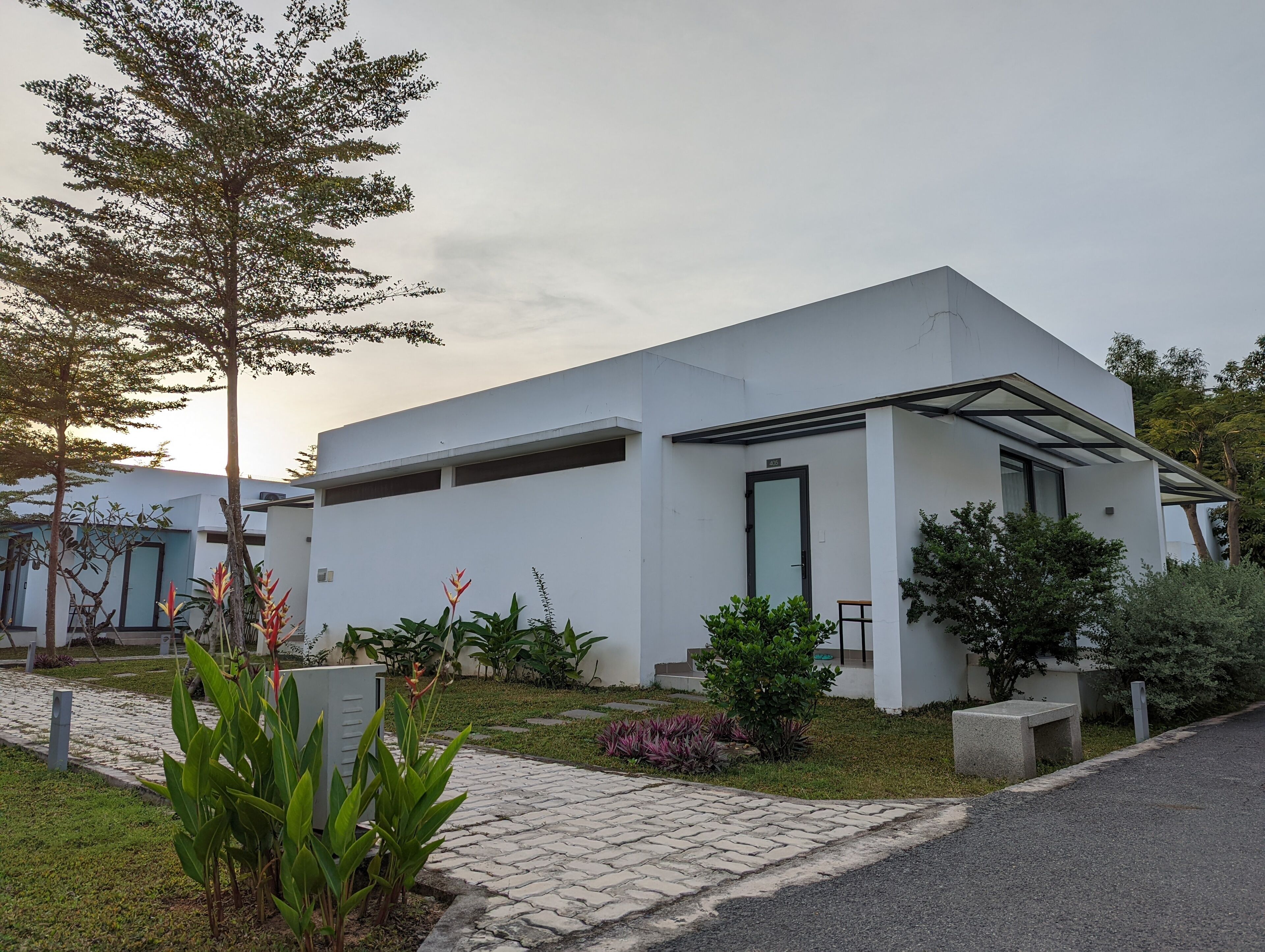 A modern building with a flat roof, large windows, and a covered entrance area.