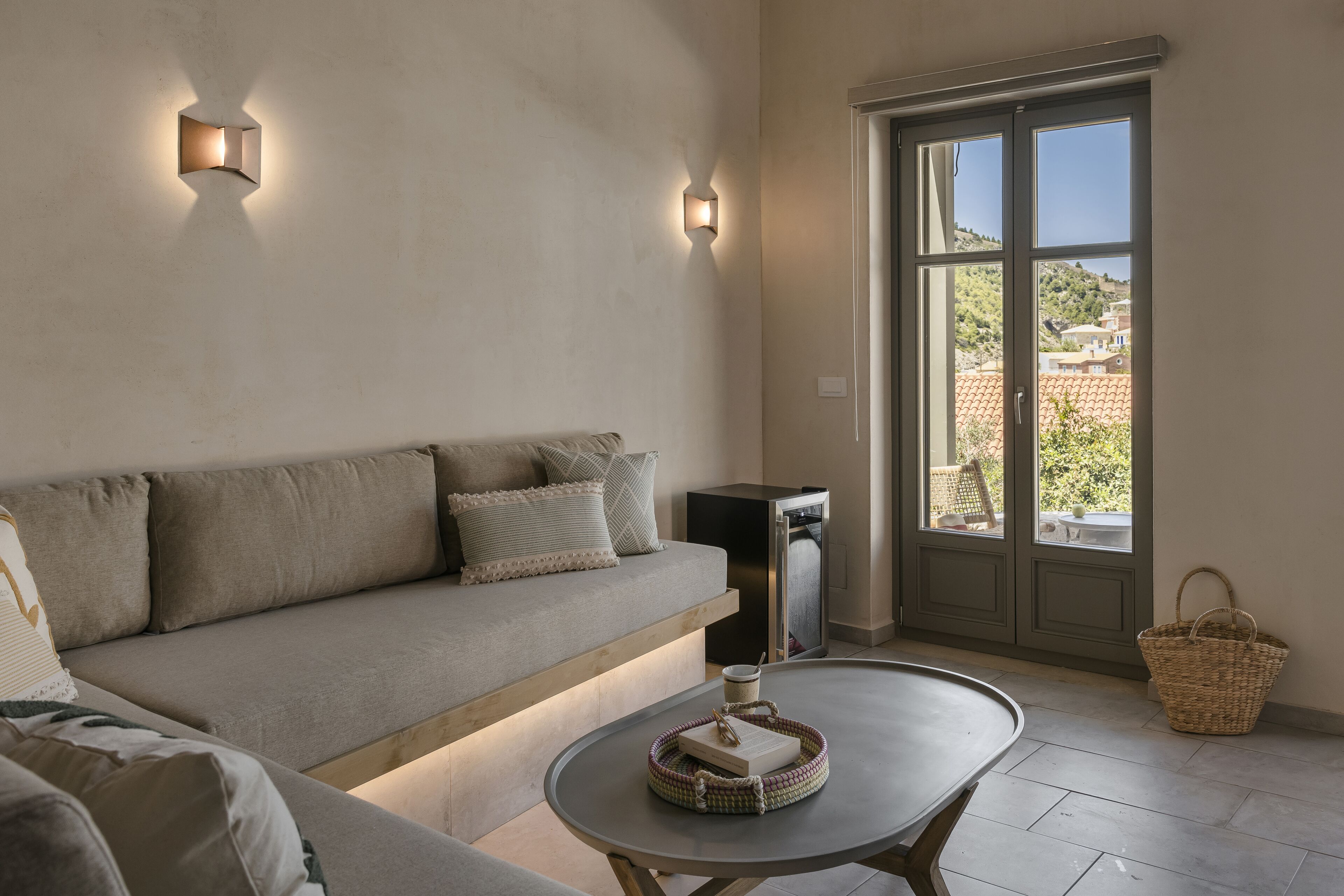 Una sala de estar moderna con un sofá, una mesa de centro y vistas a través de un ventanal.