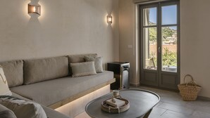 Una sala de estar moderna con un sofá, una mesa de centro y vistas a través de un ventanal.