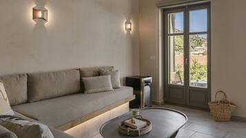 Una sala de estar moderna con un sofá, una mesa de centro y vistas a través de un ventanal.