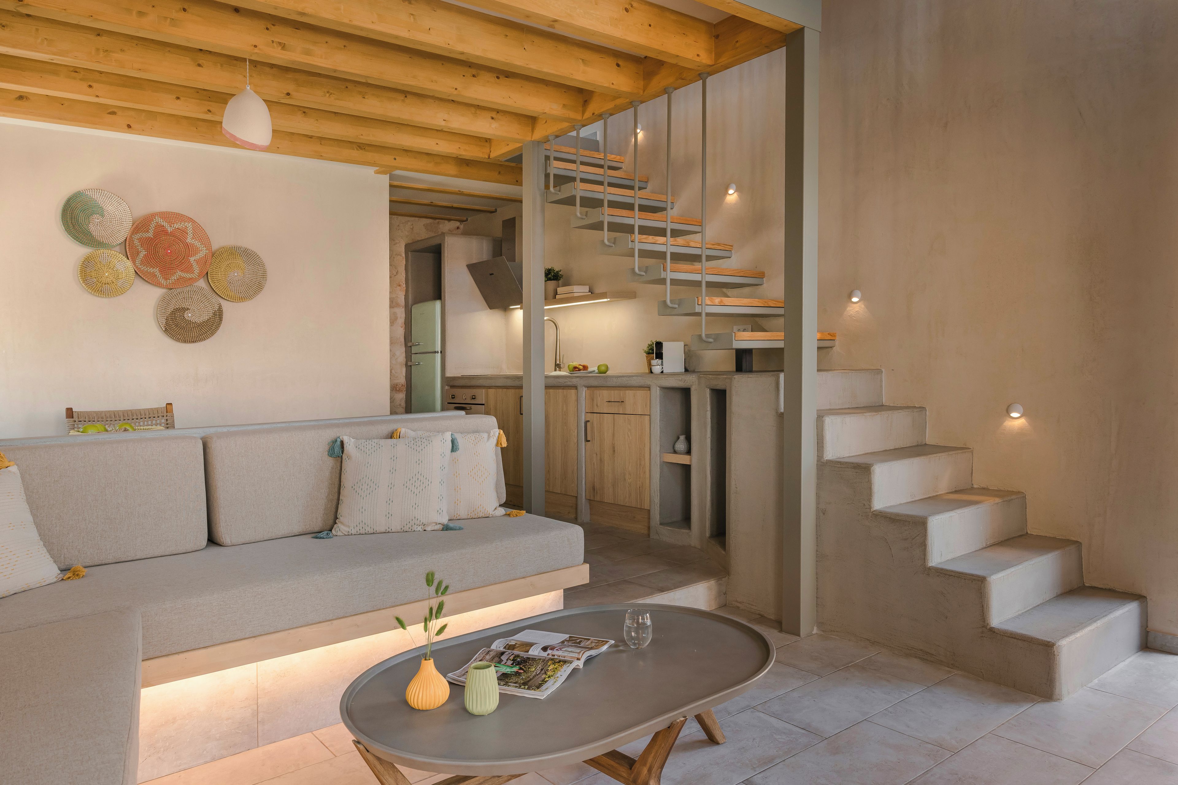 Un salon moderne avec un canapé, une table basse et un escalier menant à un niveau supérieur.