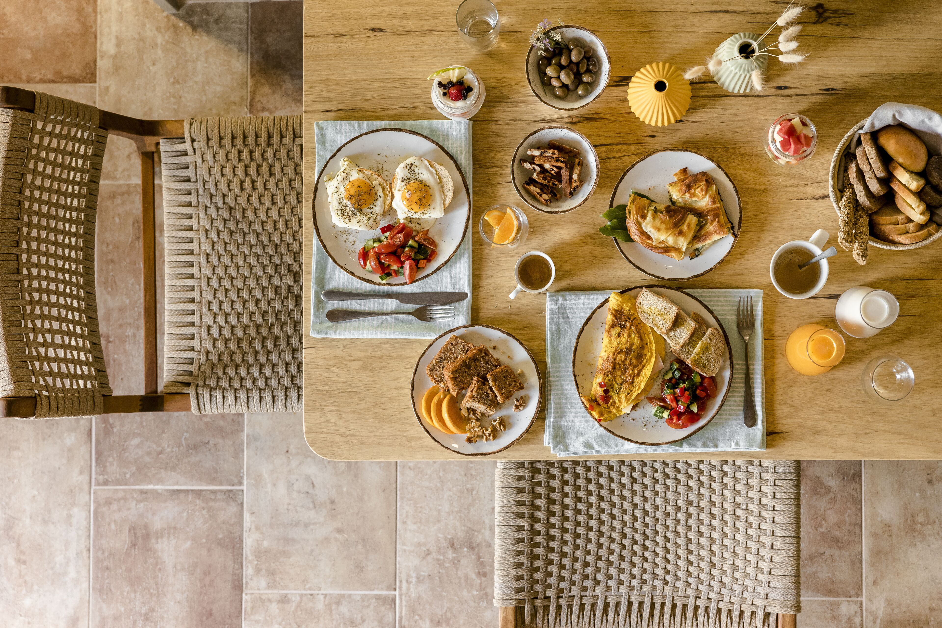A dining table with various dishes, including eggs, bread, and a fruit bowl.