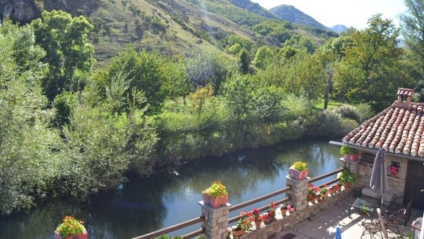 A riverside view with a stone building featuring a tiled roof and potted plants. - THE BLOCK I AND II (Cabornera)
