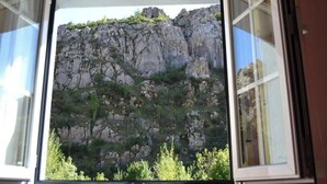 A window with a view of rocky terrain and greenery. - THE BLOCK I AND II (Cabornera)