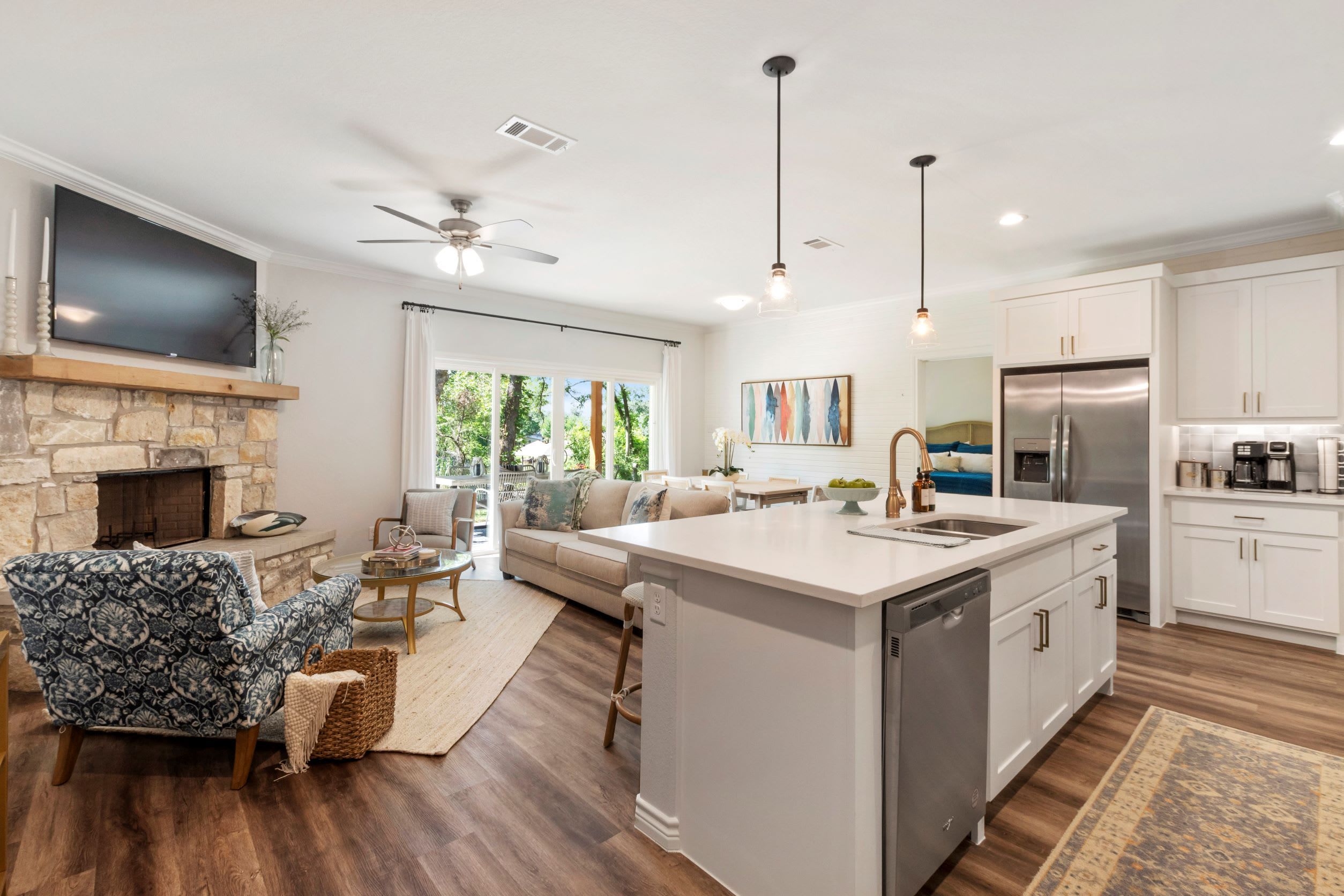 A modern kitchen with a central island, white cabinetry, and a built-in refrigerator.