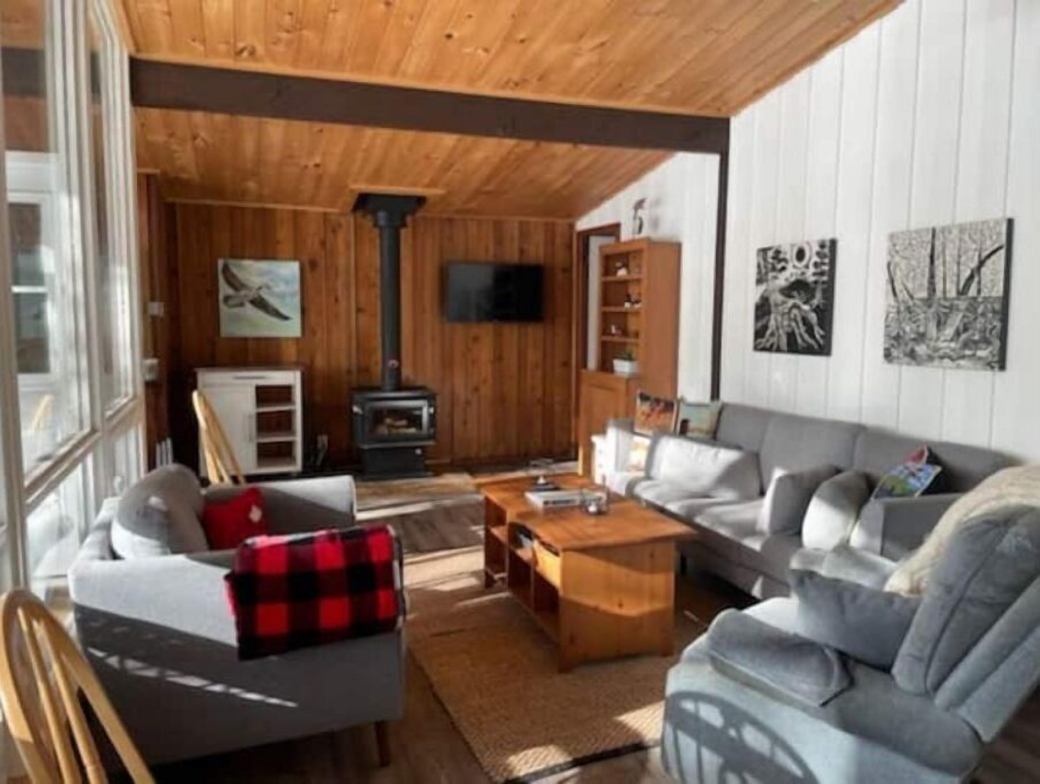 A cozy living room with a fireplace, a sofa, a coffee table, and a television.