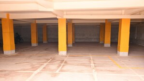 A parking garage with yellow pillars and a tiled floor. - Classic Beautiful 2-bedroom Apartment in Thika (Thika)