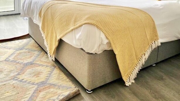 A bedroom with a bed, a window, a radiator, and a door. - Mode Apartments St Annes (Lytham St. Anne's)