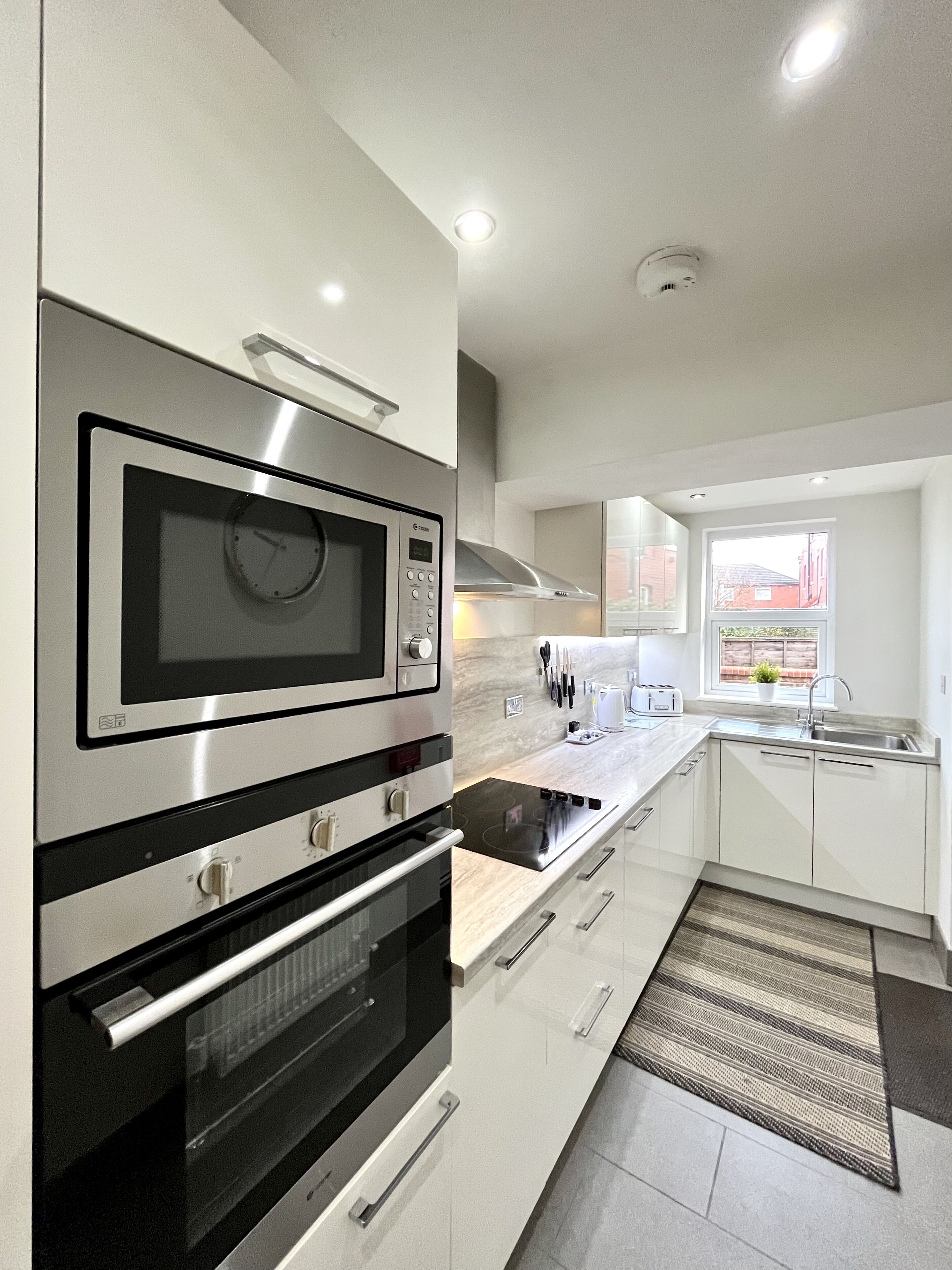 A modern kitchen with stainless steel appliances, a built-in oven, a microwave, and a gas stove.