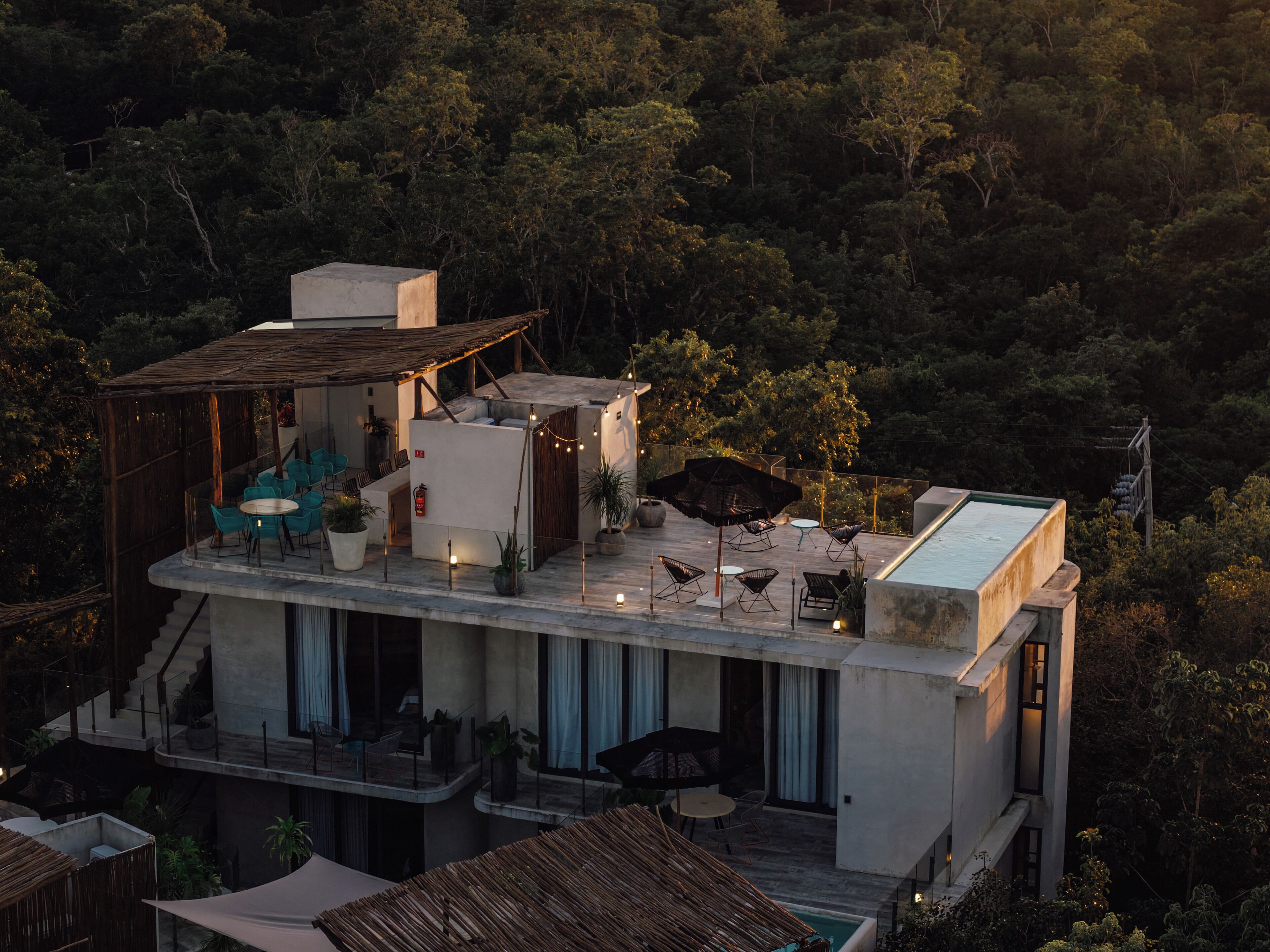 A modern villa with a rooftop terrace, outdoor seating, and a swimming pool.