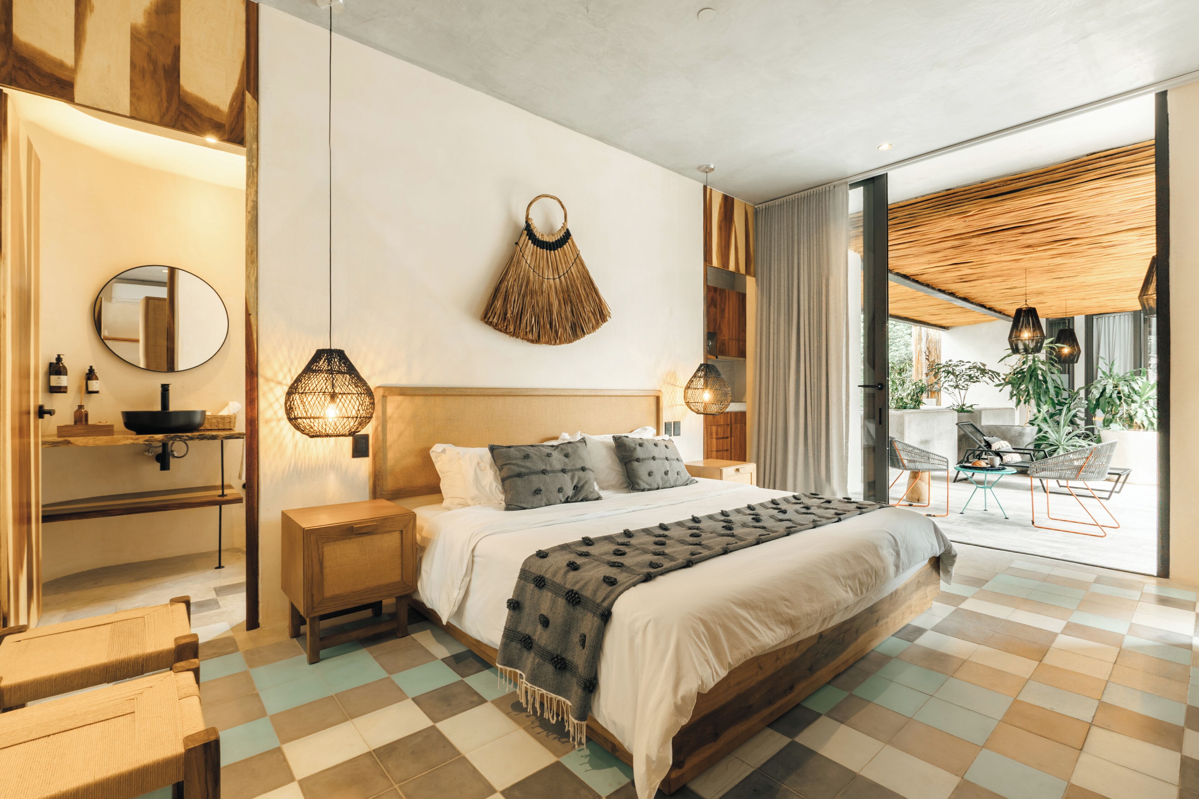 Ein modernes Schlafzimmer mit einem großen Bett, Nachttischen, einem Spiegel und einer Hängeleuchte.