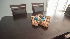 A dark wooden dining table with a woven basket containing colorful balls. - Newly Renovated Family Vacation Rental with Pool & Spa (Bradenton)