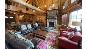 A log cabin interior with a fireplace, leather sofas, and a stone fireplace surround. - Black Forest Cabin • Near town and Stevens Pass (Leavenworth)