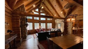 A log cabin interior with a dining area, kitchen, and seating space. - Black Forest Cabin • Near town and Stevens Pass (Leavenworth)