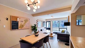 A modern living room with a wooden dining table, two chairs, a sofa, and a large window. - Elegant refined stay near WTC | Terrace (Ciudad de México)
