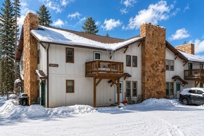 Un chalet à deux étages avec des cheminées en pierre, un balcon et une enseigne indiquant « WAPITI 2 ».