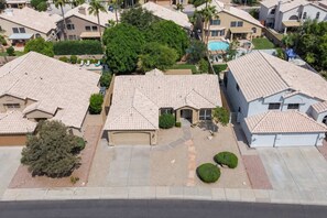 Zona residencial con varias casas, piscina y césped bien cuidado.