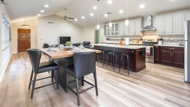 A modern kitchen with a central island, bar stools, and a dining area with chairs. - Immaculate!  Single-Story 3bdr | Chandler (Chandler)