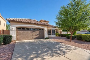 A residential house with a garage, a driveway, and a well-maintained lawn.