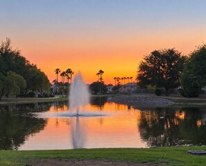 A tranquil park with a fountain, surrounded by trees and a sunset sky. - Pet-Friendly 3BR | Fenced Yard | Lake Trails (Tempe)