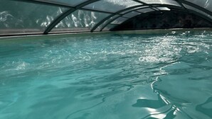 Vista despejada de una piscina interior con una estructura de techo moderna y curvada.